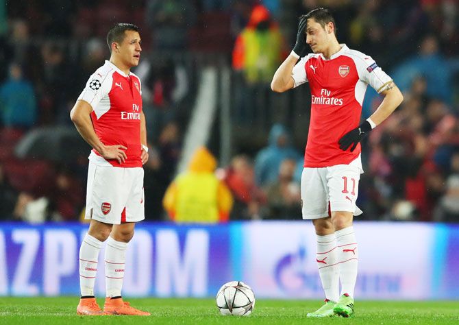 Arsenal's Alexis Sanchez (left) and Mesut Ozil show their dejection after Barcelona's first goal during their UEFA Champions League, Round of 16, second leg match at Camp Nou on March 16