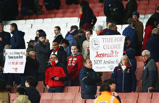 Arsenal fans hold banners after the Barclays Premier League match
