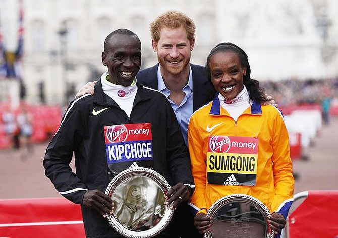 Great Britain's Prince Harry poses with London Marathon winners of the men's race Kenya's Eliud Kipchoge and the women's race Jemima Sumgong on Sunday