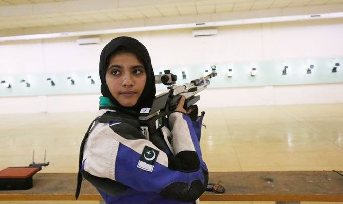 Minhal Sohail looks back as she prepares to shoot her air rifle during a practice session at the Pakistan Navy Shooting Range in Karachi on July 29, 2016