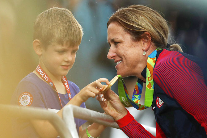  Gold medalist Kristin Armstrong of the United States shows her medal to her son Lucas William Savola after the medal ceremony for the Cycling Road Women's Individual Time Trial on Day 5 of the Rio 2016 Olympic Games at Pontal in Rio de Janeiro on Wednesday