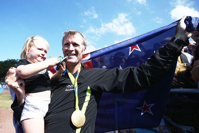 Gold medalist Mahe Drysdale of New Zealand celebrates with his daughter Bronte after the medal ceremony for the Men's Single Sculls on Saturday