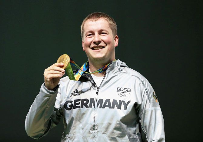 Gold medalist Christian Reitz of Germany poses on the podium during the medal ceremony for the Men's Rapid Fire pistol event at the Olympic Shooting Centre on Saturday