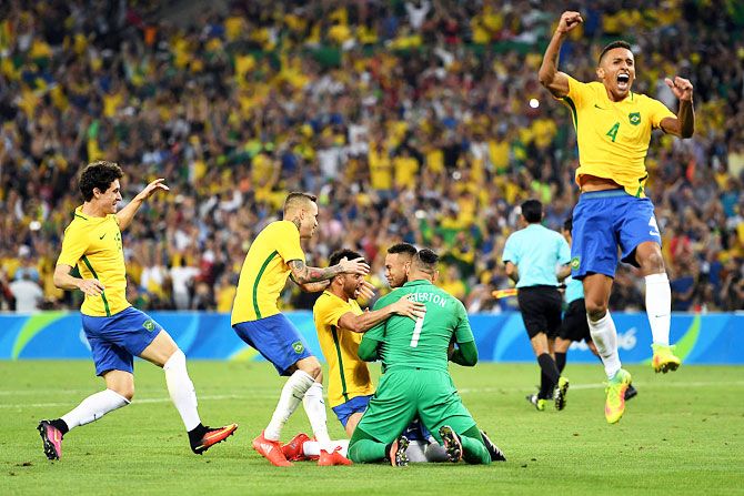 Neymar of Brazil is surrounded by teammates as he celebrates after scoring the winning penalty in the penalty shoot out during the men's football final against Germany at the Maracana Stadium at the Rio 2016 Olympic Games on Saturday