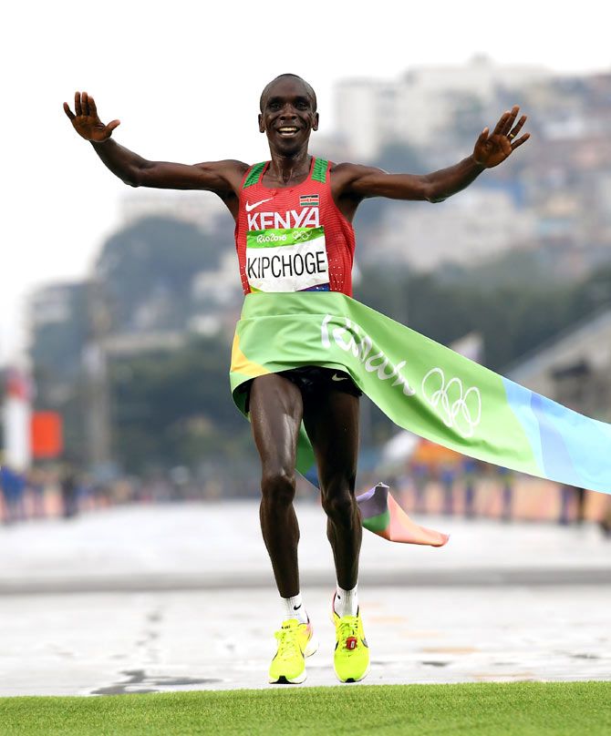 Kenya Eliud Kipchoge celebrates as he crosses the line to win gold in the men's marathon