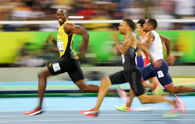 Usain Bolt of Jamaica looks at Andre De Grasse of Canada as they compete in the men’s 100m semi-final at Olympic Stadium in Rio de Janeiro on August 14