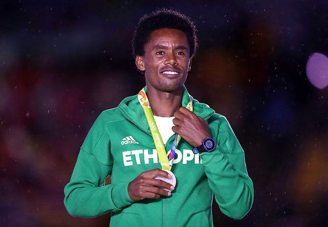 Ethiopia's silver medallist Feyisa Lilesa stands on the podium during the medal ceremony for the Men's Marathon at the Rio 2016 Olympic Games at Maracana Stadium on August 21