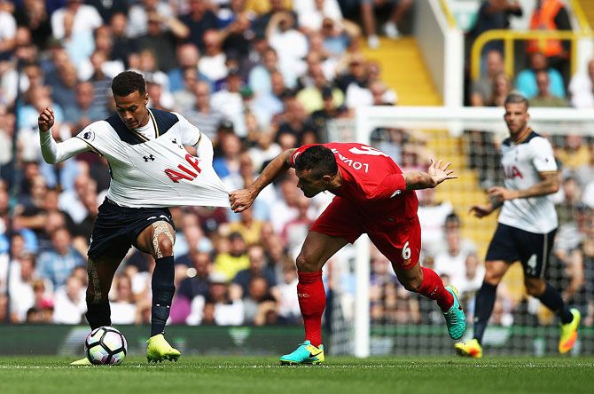 Tottenham Hotspur’s Dele Alli gets his shirt pulled by Liverpool’s Dejan Lovren during their English Premier League match at White Hart Lane on Saturday, August 27