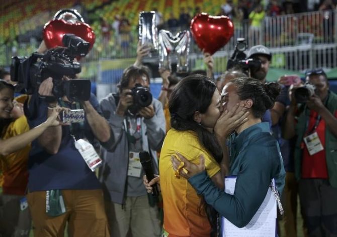 Rugby player Isadora Cerullo (BRA) of Brazil kisses Marjorie, a volunteer, after receiving her wedding proposal on the sidelines of the women's rugby medal ceremony