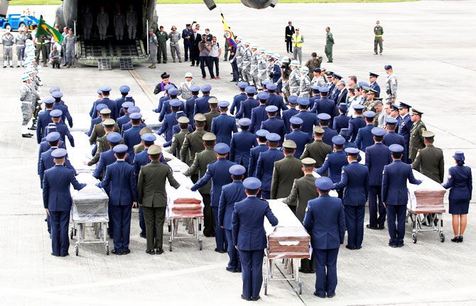 Military personnel unload a coffin with the remains of Brazilian victims who died in an accident of the plane that crashed into the Colombian jungle with Brazilian soccer team Chapecoense, at the airport from where the bodies will be flown home to Brazil, in Medellin, Colombia on Friday
