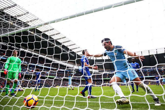 Manchester City's Ilkay Gundogan celebrates his team's first goal as Chelsea's Gary Cahill scores an own goal