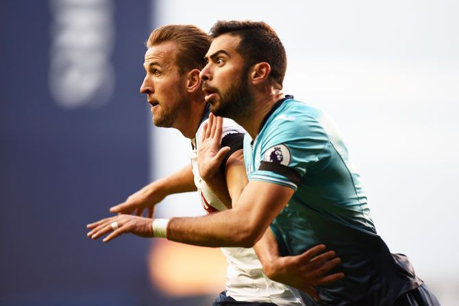 Tottenham Hotspur's Harry Kane and Swansea City's Jordi Amat tussle as they vie for the ball during their Premier League match at White Hart Lane in London on Saturday