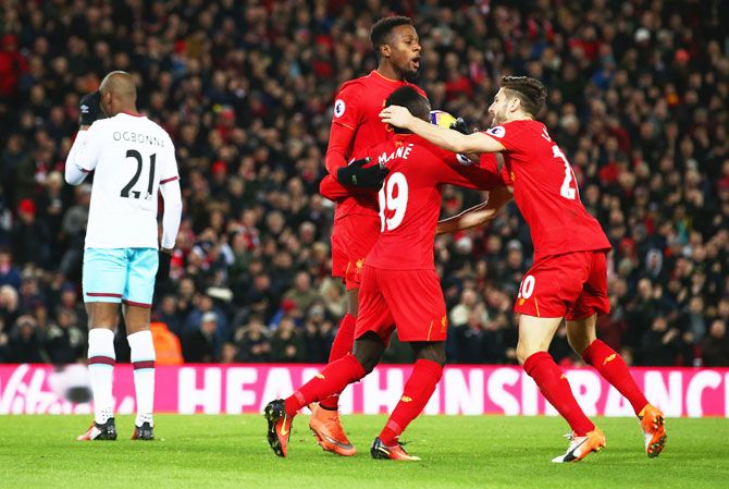 Liverpool's Divock Origi celebrates his equaliser with Adam Lallana (20) and Sadio Mane (19) as West Ham United Angelo Ogbonna looks dejected during their Premier League match at Anfield in Liverpool, on Sunday