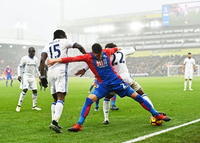 Crystal Palace's Joel Ward (centre) battles for the ball with Chelsea's Willian (right)