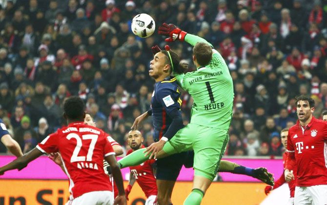 Bayern Munich's goalkeeper Manuel Neuer in an aerial duel with RB Leipzig's Yussuf Poulsen