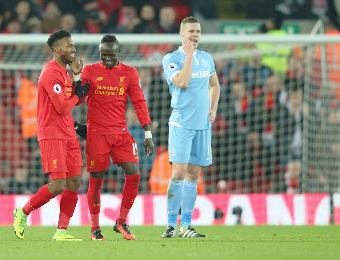 Stoke City's Ryan Shawcross (right) looks dejected as Liverpool's Daniel Sturridge (left) celebrates with teammate Sadio Mane after scoring the fourth goal