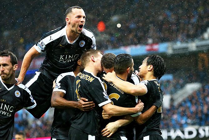 Leicester City's Robert Huth (obscured) is mobbed by teammtes after scoring his team's first goal during their Barclays Premier League match against Manchester City at the Etihad Stadium in Manchester on Saturday
