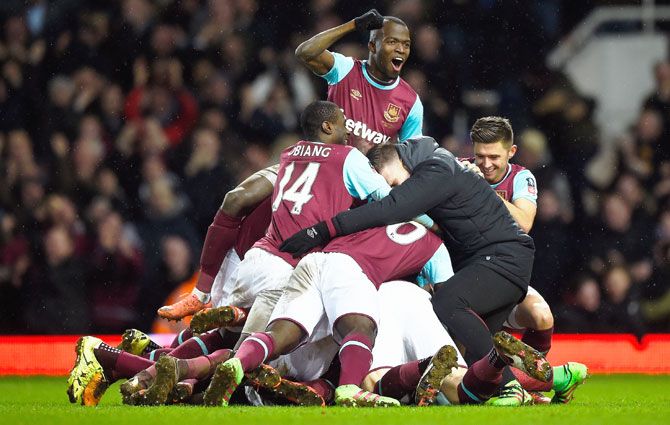 West Ham United's Angelo Ogbonna Obinza is mobbed by teammates after he headed in the winner against Liverpool during their FA Cup fourth round replay match at Boleyn Ground in London on Tuesday