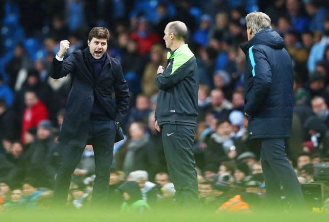 Tottenham Hotspur's manager Mauricio Pochettino (left) celebrates victory as Manchester City manager Manuel Pellegrini (right) looks on