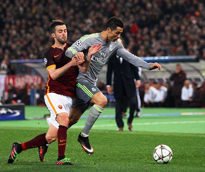 Real Madrid's Cristiano Ronaldo (right) wins the ball in a challenge against AS Roma's Miralem Pjanic