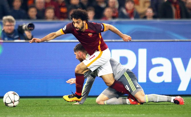 AS Roma's Mohamed Salah (left) runs with the ball past Real Madrid's Sergio Ramos