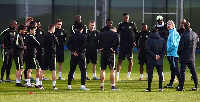 Manager of Manchester City Manuel Pellegrini, right, talks to his players during a training session