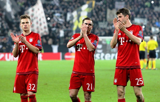 Joshua Kimmich, Philipp Lahm and Thomas Muller of FC Bayern Muenchen salute the fans 