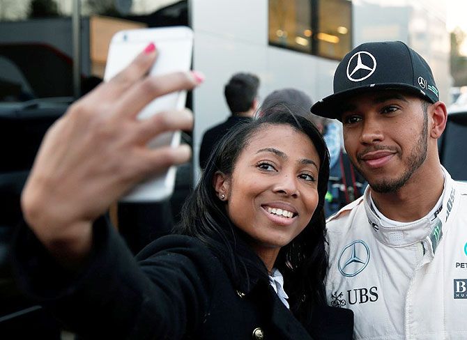 Mercedes Formula One driver, Britain'S Lewis Hamilton poses for a selfie with a fan after the third testing session ahead the upcoming season at the Circuit Barcelona-Catalunya in Montmelo, Spain, on Wednesday