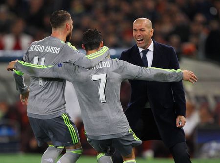 Real Madrid’s Cristiano Ronaldo celebrates with teammate Sergio Ramos and manager Zinedine Zidane after scoring the opening goal against AS Roma during their UEFA Champions League round of 16 first leg match at Stadio Olimpico in Rome on Wednesday