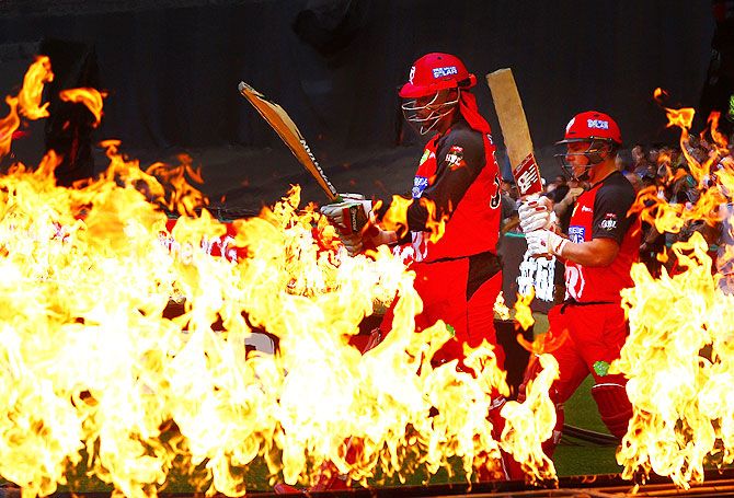 Chris Gayle and Aaron Finch of the Melbourne Renegades walk through flames to open the batting during their Big Bash League match against the Perth Scorchers at Etihad Stadium in Melbourne on December 30, 2015