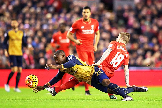Arsenal's Joel Campbell and Liverpool's Alberto Moreno vie for possession