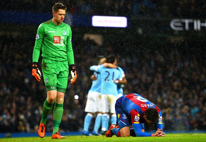 Crystal Palace's Joel Ward lies on the turf dejected as keeper Wayne Hennessey looks on after Manchester City's David Silva scored his team's fourth goal at Etihad Stadium