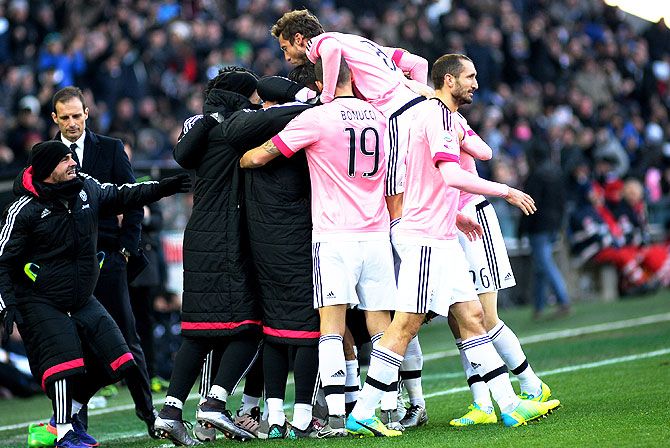 Juventus FC's Paulo Dybala is mobbed by teammates after scoring his team's opening goal against Udinese Calcio