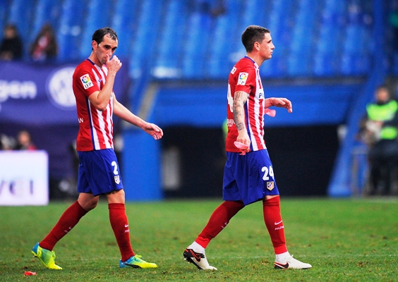 Jose Maria Gimenez (24) and Diego Godin of Atletico Madrid leave the pitch dejected 