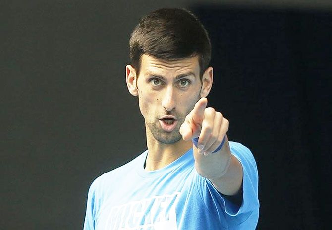 Serbia's Novak Djokovic gestures during a practice session on the eve of his final match against Britain's Andy Murray, at the Australian Open tennis tournament at Melbourne Park