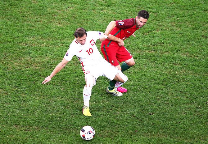 Poland’s Grzegorz Krychowiak and Portugal’s Joao Moutinho compete for the ball
