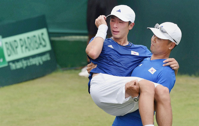 South Korea's Seon Chan Hong is assisted by medical staff after suffering an injury during his Davis Cup singles against Ramkumar Ramanathan at the Asia/Oceania Group-I tie at Chandigarh on Friday