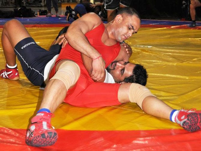 Wrestler Vinod Kumar (in red) tackles with another wrestler at a gym in Melbourne, Australia