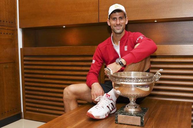 Novak Djokovic poses with trophy after winning the French Open on Sunday