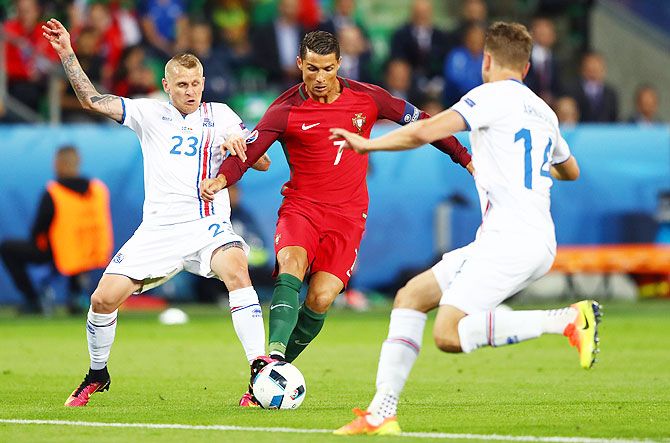 Portugal's Cristiano Ronaldo (centre) is challenged by Iceland's Ari Skulason (left) and Kari Arnason during their Euro 2016 Group F match at Stade Geoffroy-Guichard in Saint-Etienne, on Tuesday