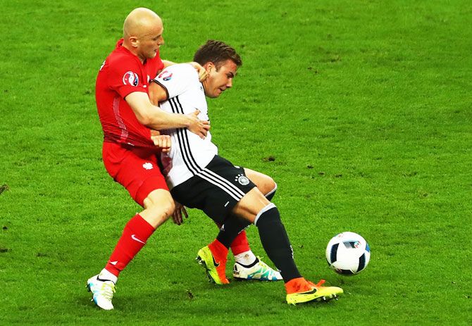 Germany's Mario Goetze wins the ball as he is challenged by Poland's Michal Pazdan
