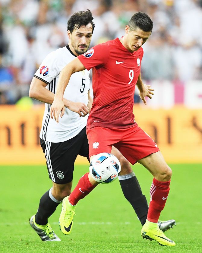 Poland's Robert Lewandowski controls the ball under pressure of Germany's Mats Hummels