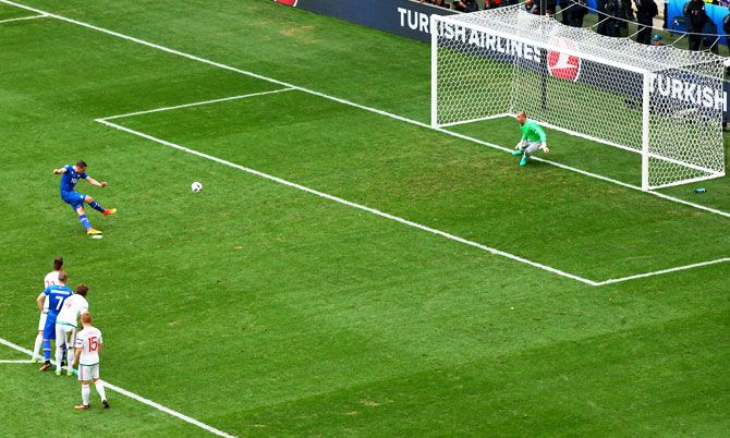 Iceland's Gylfi Sigurdsson shoots past Hungary keeper Gabor Kiraly to convert from the penalty spot