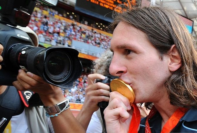 Argentinian forward Lionel Messi kisses his gold medal as he leaves the pitch after attending the men's Olympic football tournament medal ceremony at the national stadium in Beijing during the 2008 Beijing Olympic games on August 23, 2008