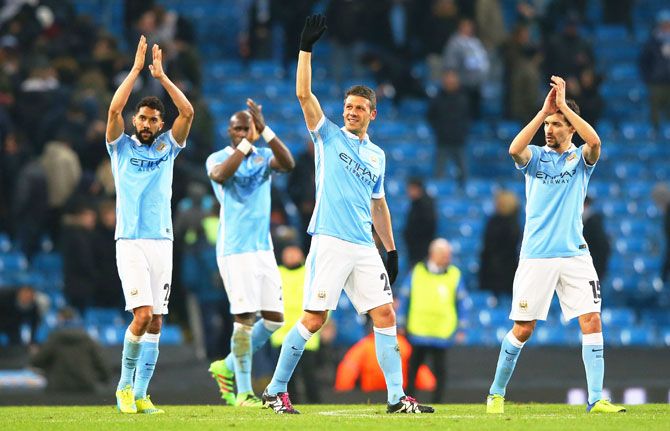 Manchester City's Gael Clichy, Martin Demichelis and Jesus Navas acknowledge the crowd after their 0-0 draw against FC Dynamo Kyiv, in their UEFA Champions League round of 16, second leg match at the Etihad Stadium in Manchester on Tuesday