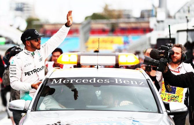 Mercedes GP's Lewis Hamilton celebrates in the pitlane after getting pole position during qualifying for the Australian Formula One Grand Prix at Albert Park in Melbourne, Australia, on Saturday