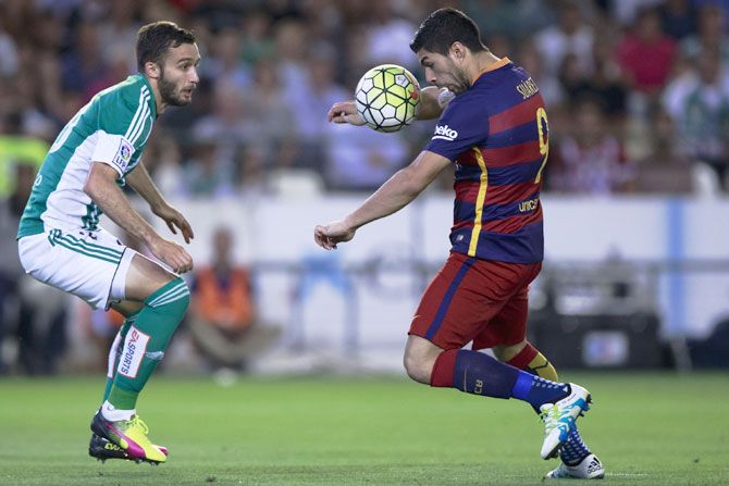 FC Barcelona's Luis Suarez (right) competes for the ball with Real Betis's German Pezzella (left) during their La Liga match at Estadio Benito Villamarin in Seville on Saturday, April 30