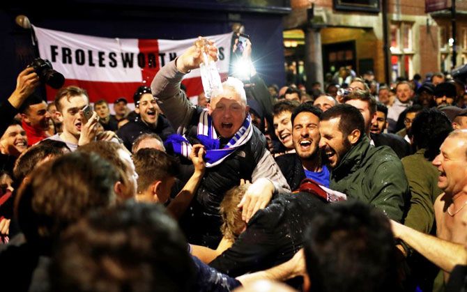 Leicester City fans celebrate winning the Premier League in a pub in Leicester on Monday