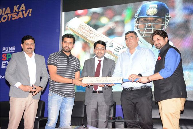 Rohit Sharma presents a signed bat to Gagan Narang at the the Pune International Sports Expo (PISE) at the College of Agriculture Grounds in Pune on Thursday