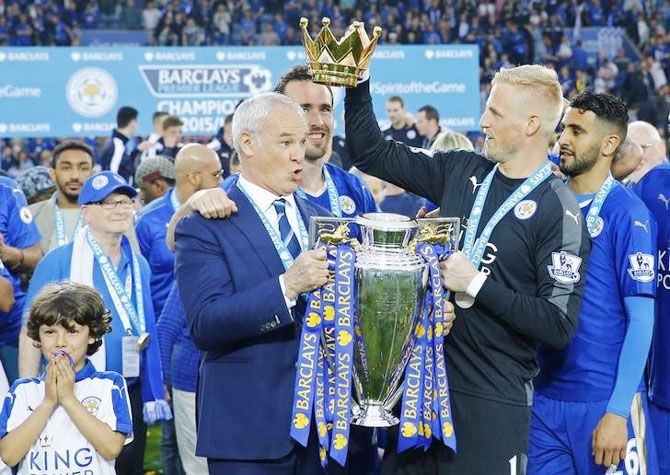 Leicester City manager Claudio Ranieri holds the trophy as he celebrates winning the Barclays Premier League with 'keeper Kasper Schmeichel and teammates